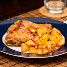 Cosce di pollo al forno servite con patate arrosto